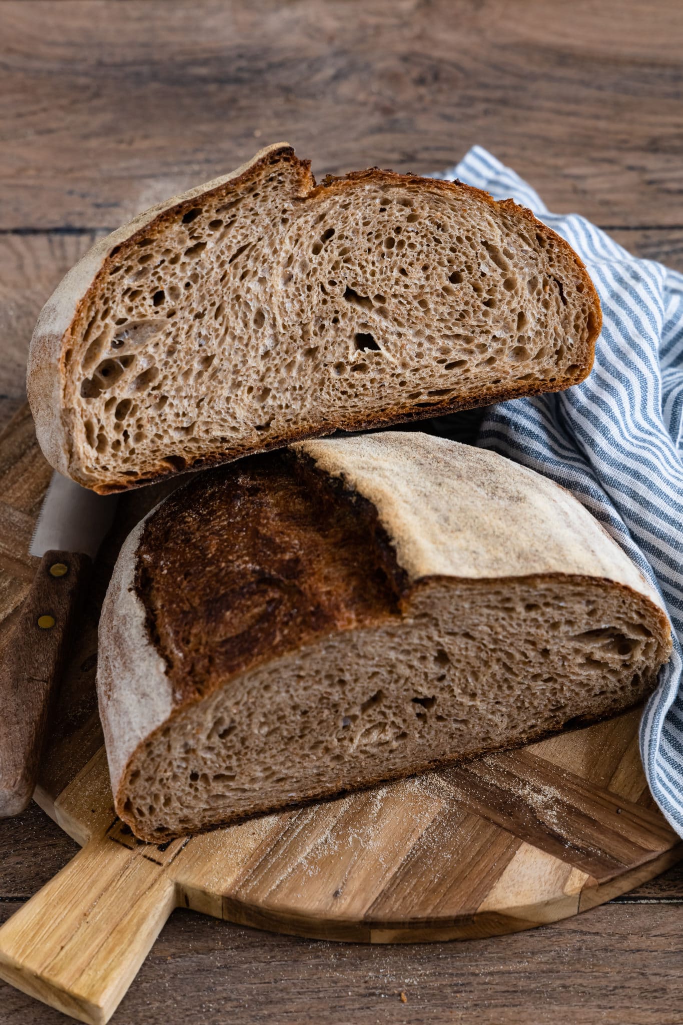 Rustikales Auffrischbrot "Jule 2.0" mit Sauerteigresten aufgeschnitten auf einem Holzbrett.